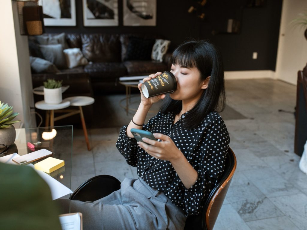 Women checking smartphone coffee drinking